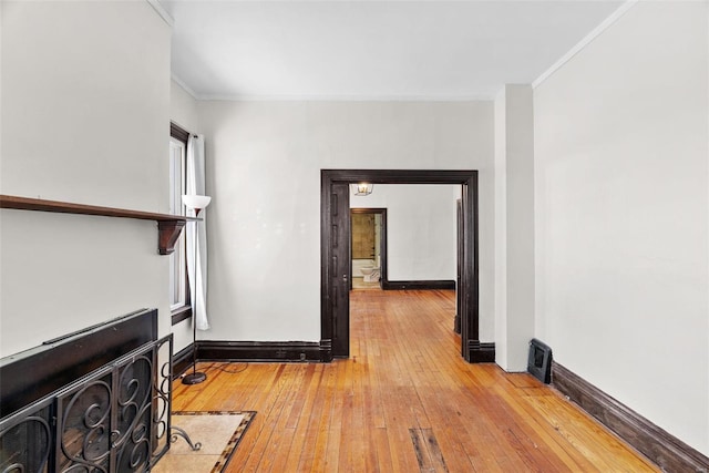 hallway with ornamental molding and hardwood / wood-style floors