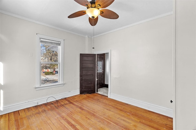 spare room with ornamental molding, ceiling fan, and wood-type flooring