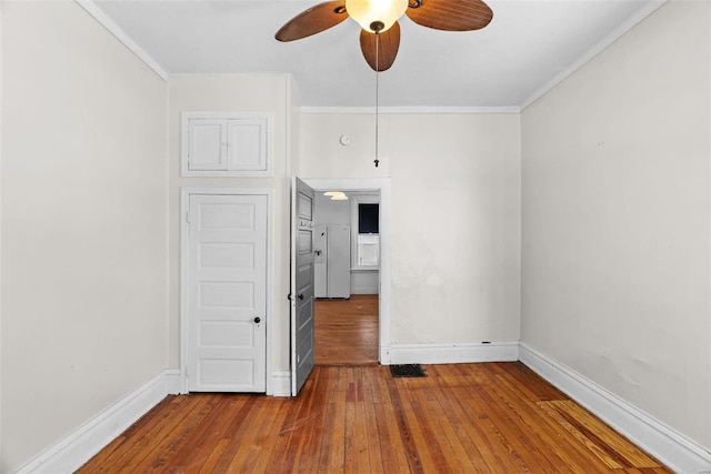 unfurnished room with hardwood / wood-style floors, ceiling fan, and crown molding