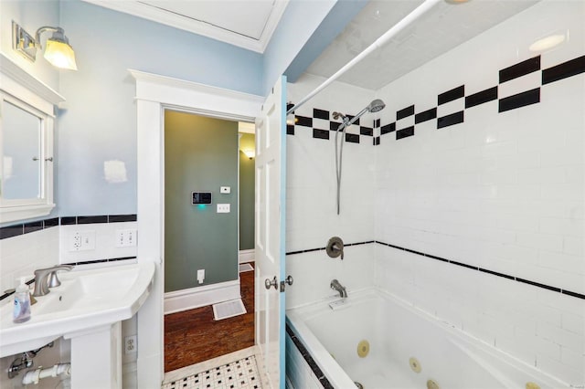 bathroom featuring tiled shower / bath combo, sink, and crown molding