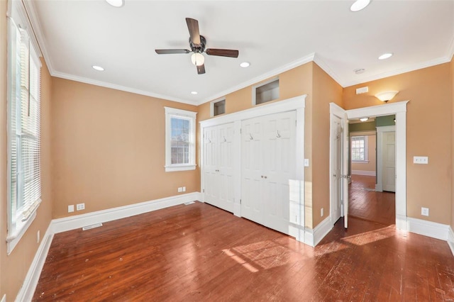 unfurnished bedroom with hardwood / wood-style floors, ceiling fan, crown molding, and a closet