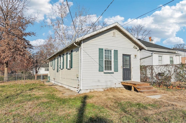 rear view of property featuring a lawn