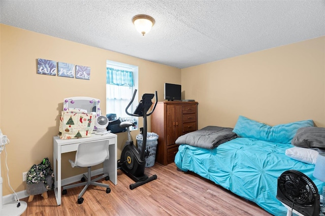 bedroom featuring a textured ceiling and light hardwood / wood-style floors