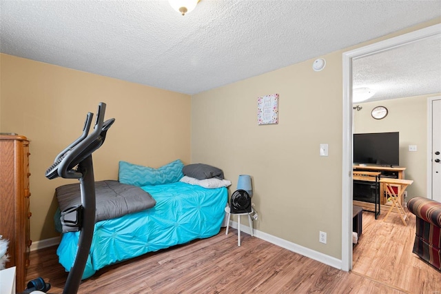 bedroom with a textured ceiling and light hardwood / wood-style flooring