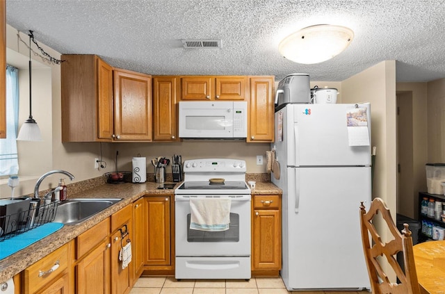 kitchen featuring sink, hanging light fixtures, a textured ceiling, white appliances, and light tile patterned floors