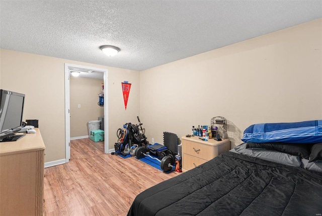 bedroom with a textured ceiling and light hardwood / wood-style flooring