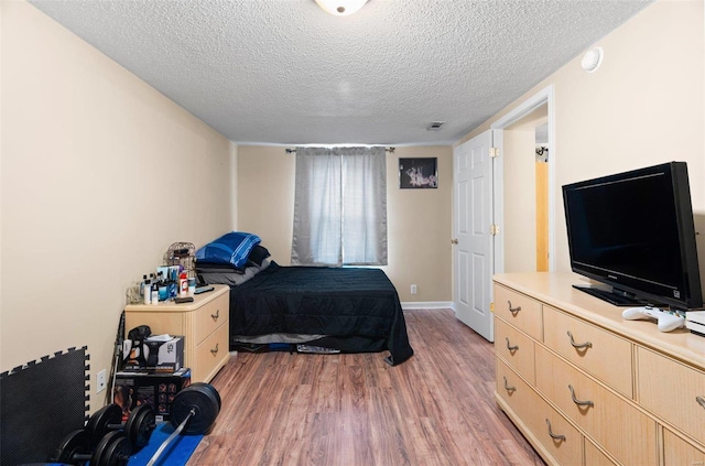 bedroom featuring wood-type flooring and a textured ceiling