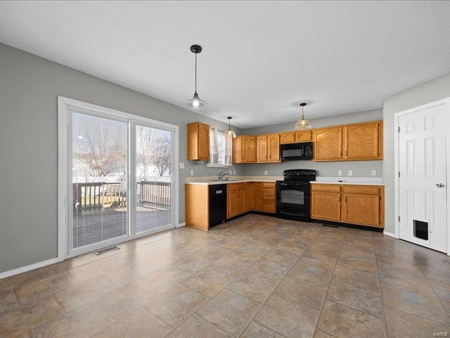 kitchen featuring black appliances, sink, and hanging light fixtures