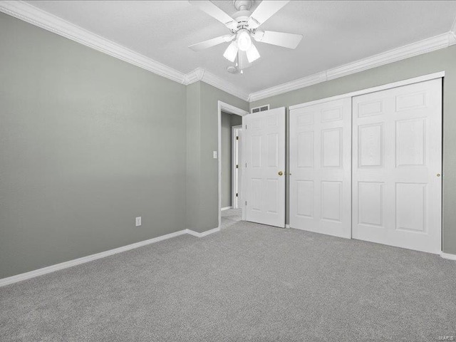 unfurnished bedroom with carpet, a closet, ceiling fan, and ornamental molding