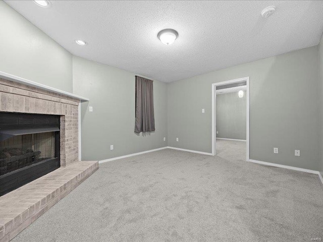 unfurnished living room with a fireplace, a textured ceiling, and light colored carpet