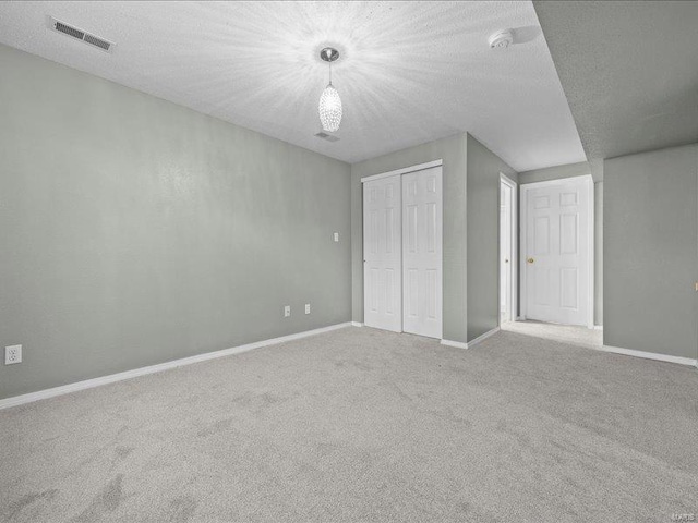 unfurnished bedroom with a textured ceiling, carpet floors, and a closet