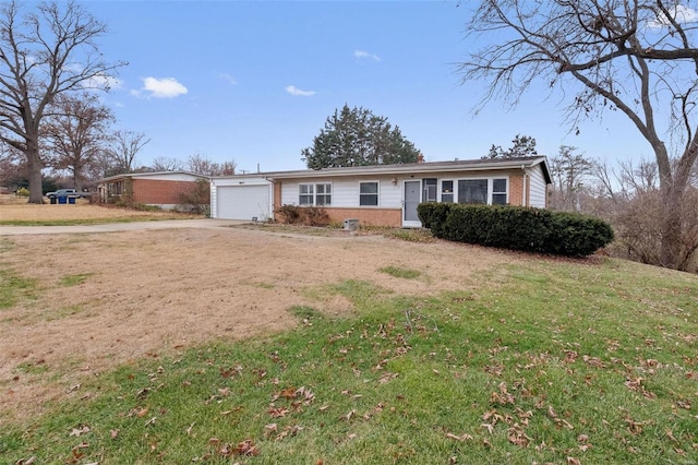 ranch-style home with a garage and a front lawn