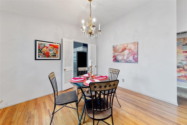 dining room featuring light wood-type flooring and an inviting chandelier