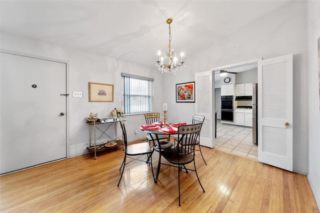 dining area with light hardwood / wood-style flooring and an inviting chandelier