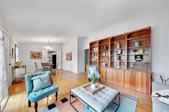 living room with light wood-type flooring and an inviting chandelier