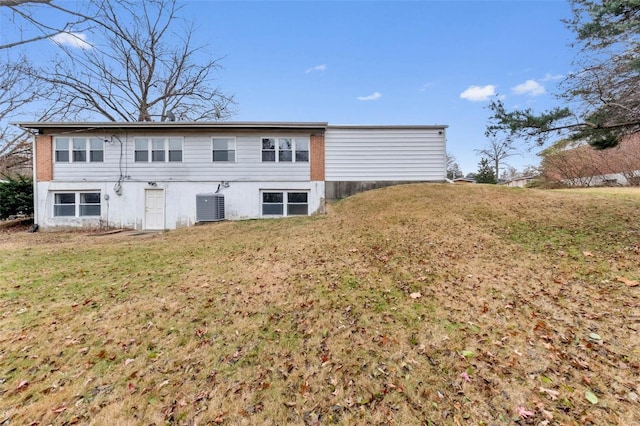 back of property with a yard and central AC