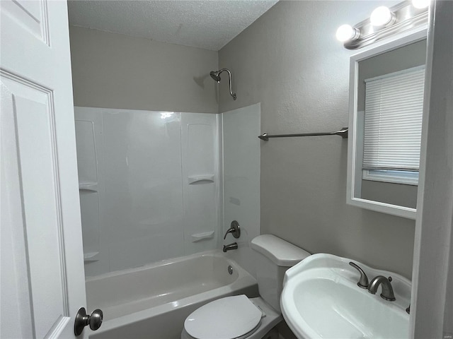 full bathroom with a textured ceiling, shower / bathing tub combination, toilet, and sink