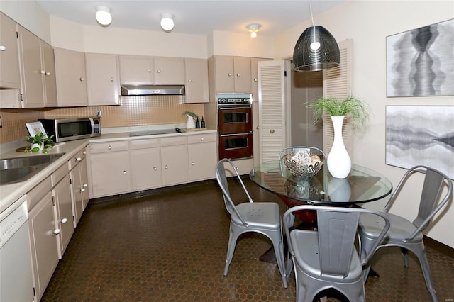 kitchen with sink, multiple ovens, white dishwasher, decorative light fixtures, and black electric cooktop