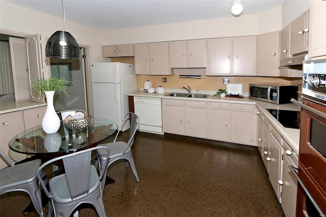 kitchen featuring white appliances, backsplash, hanging light fixtures, and sink