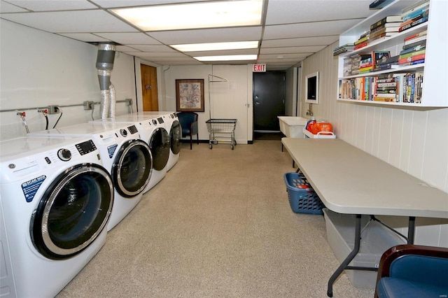 clothes washing area featuring independent washer and dryer and wooden walls