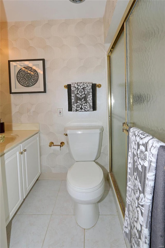 bathroom featuring tile patterned flooring, vanity, an enclosed shower, and toilet