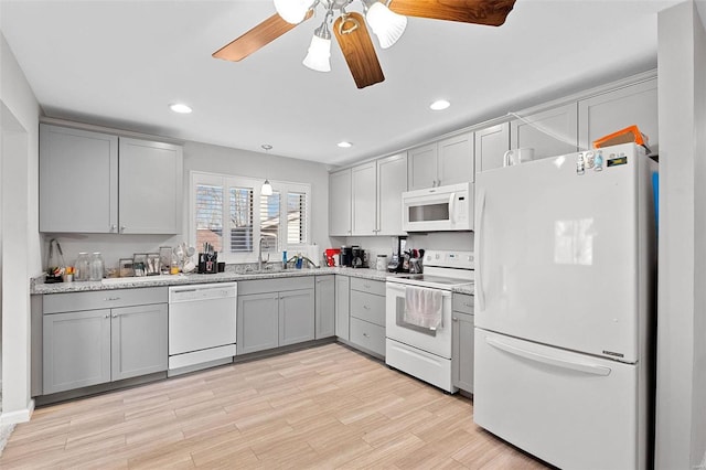 kitchen featuring white appliances, ceiling fan, sink, gray cabinets, and light hardwood / wood-style floors