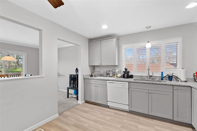 kitchen with light stone countertops, light hardwood / wood-style floors, sink, dishwasher, and gray cabinets