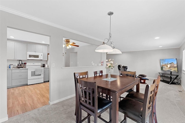 carpeted dining area featuring ceiling fan and ornamental molding