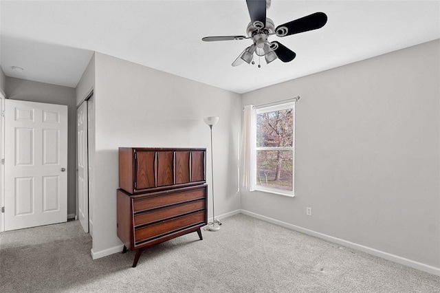 bedroom featuring a closet, light colored carpet, and ceiling fan