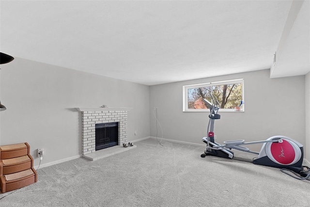 workout area featuring light carpet and a brick fireplace