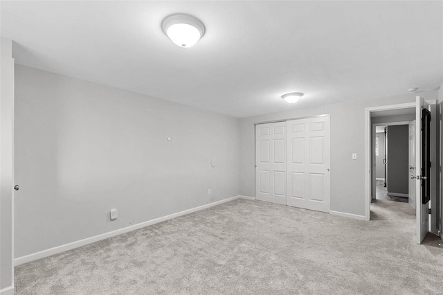 unfurnished bedroom featuring light carpet and a closet