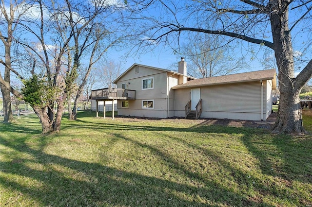 back of property with a wooden deck and a yard