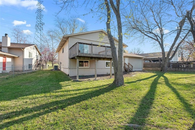 back of house with a deck and a lawn