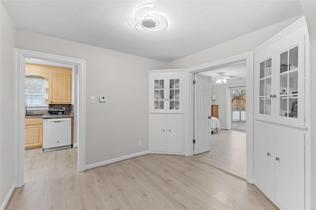 unfurnished dining area with light wood-type flooring and baseboards