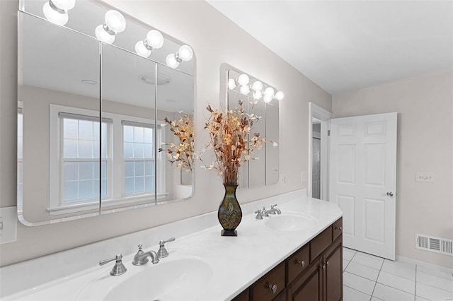 bathroom with tile patterned flooring, double vanity, visible vents, and a sink