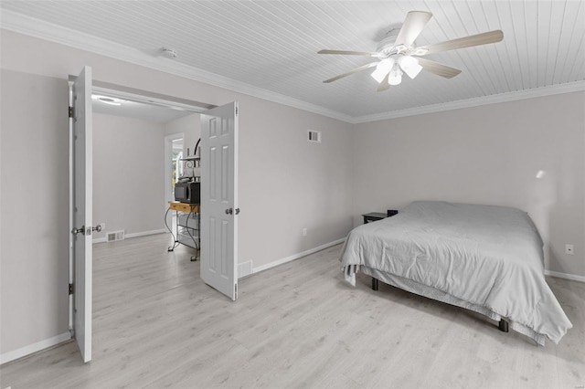 bedroom featuring baseboards, light wood-style floors, visible vents, and ornamental molding