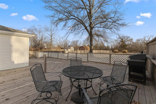 wooden terrace featuring outdoor dining space and grilling area