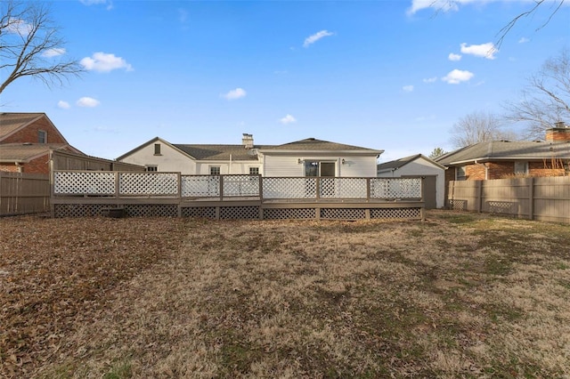 rear view of property featuring a fenced backyard and a wooden deck