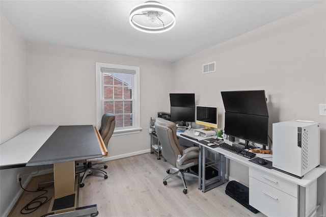 office space featuring visible vents, baseboards, and light wood finished floors