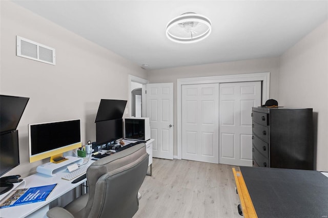 office space featuring light wood-type flooring and visible vents