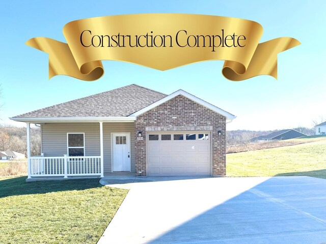 view of front of house featuring a front lawn, covered porch, and a garage