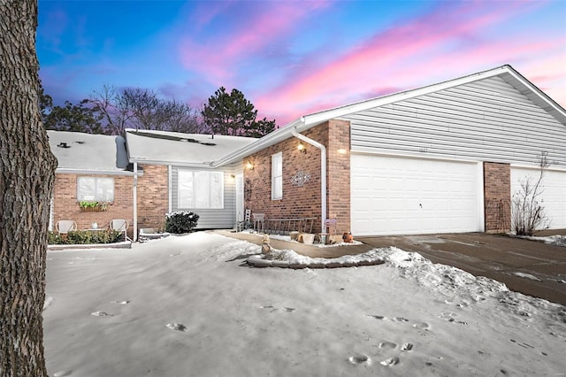 view of property exterior featuring an attached garage, brick siding, and driveway