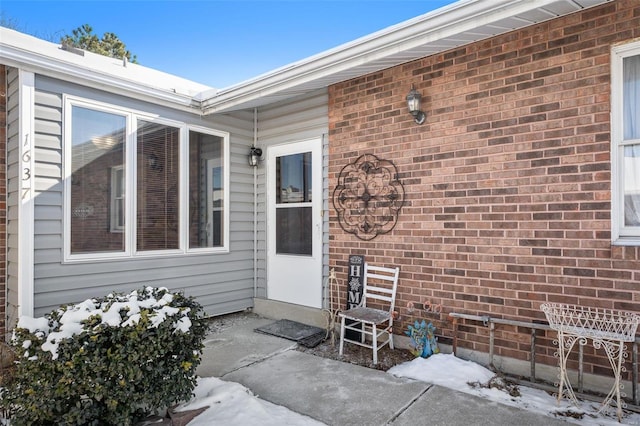 view of exterior entry with brick siding