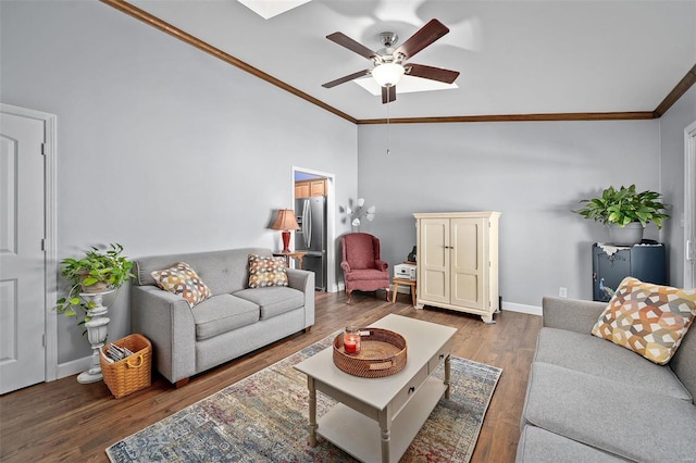 living area featuring crown molding, ceiling fan, baseboards, vaulted ceiling, and wood finished floors