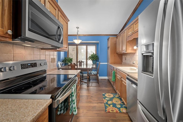 kitchen with dark wood-style flooring, a sink, stainless steel appliances, light countertops, and tasteful backsplash