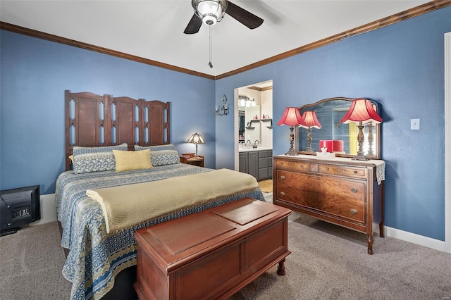 carpeted bedroom featuring a ceiling fan, ensuite bathroom, a sink, crown molding, and baseboards