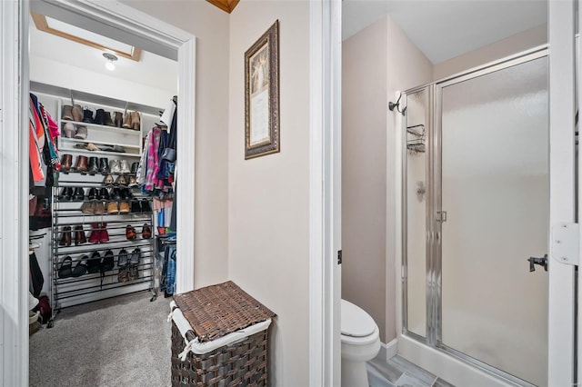 full bath featuring a spacious closet, toilet, and a stall shower