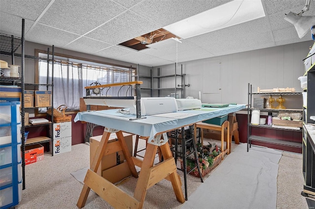 basement with a paneled ceiling and carpet floors