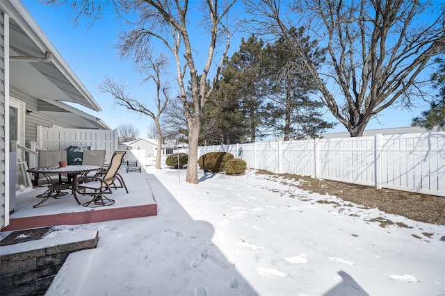 snowy yard with a fenced backyard