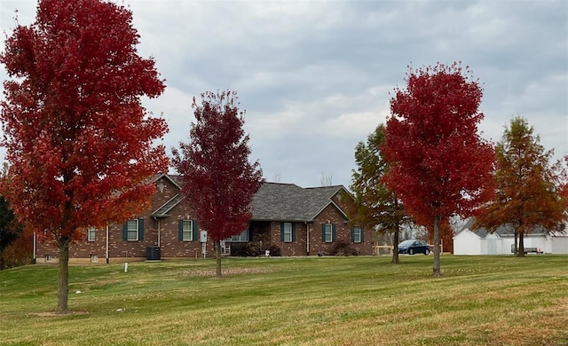 view of front of property with a front yard and central AC